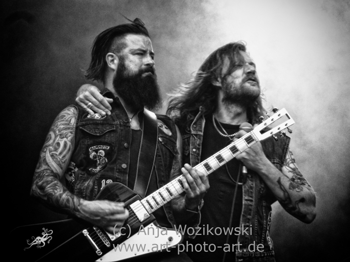 Musik- & Konzertfotografie Konzertfoto von einem Sänger und einem Gitarristen mit Bärten und Tattoos in Schwarzweiss